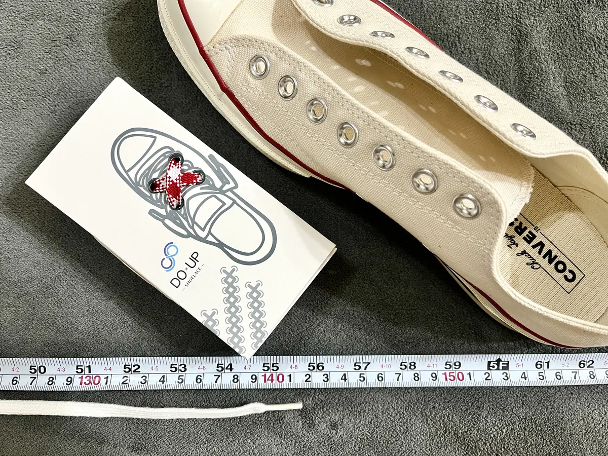 Converse All Star 低筒 7 孔的原廠鞋帶拆下後平放，以捲尺量測約 140 公分